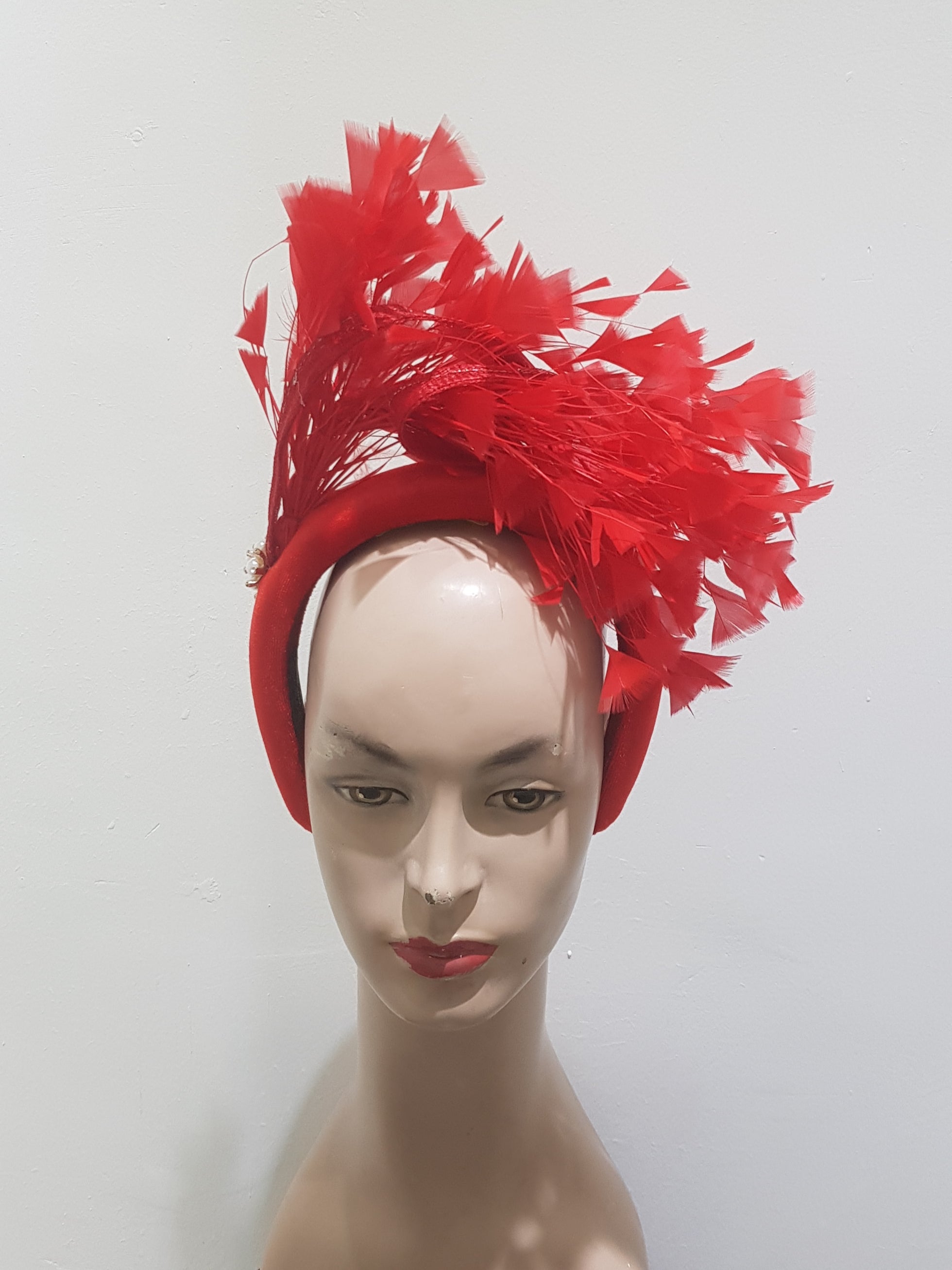 "Feather cluster on a padded headband with sinamay loops around the feathers"