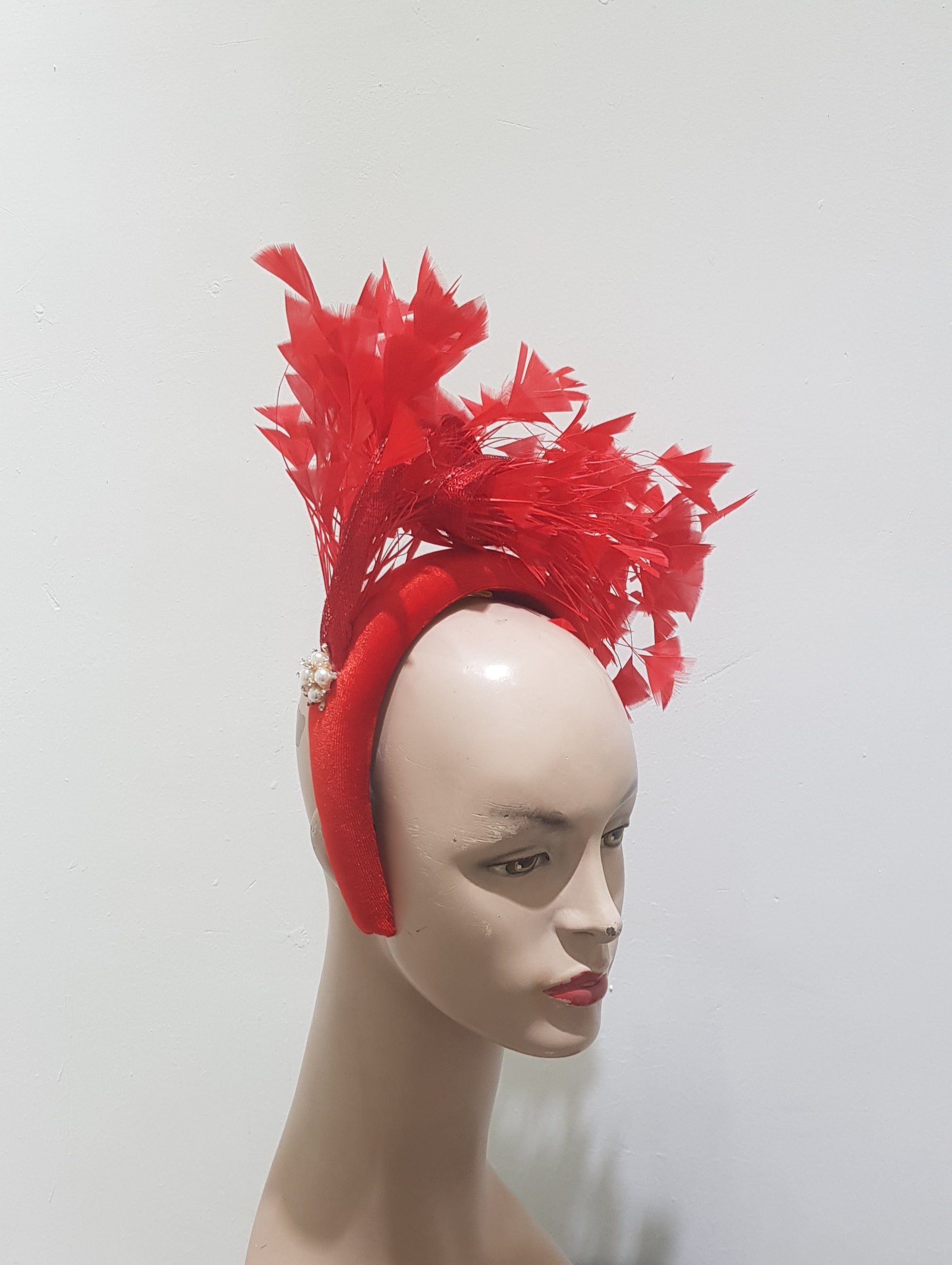 "Feather cluster on a padded headband with sinamay loops around the feathers"