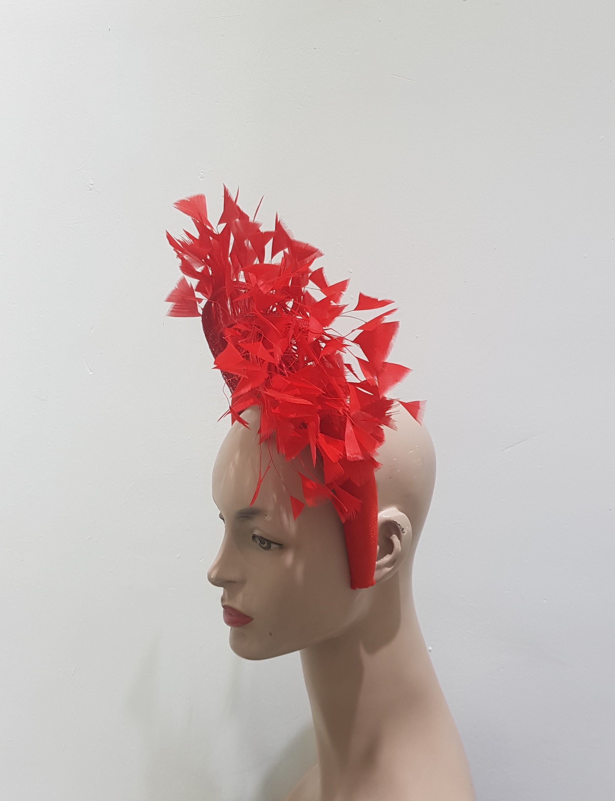 "Feather cluster on a padded headband with sinamay loops around the feathers"