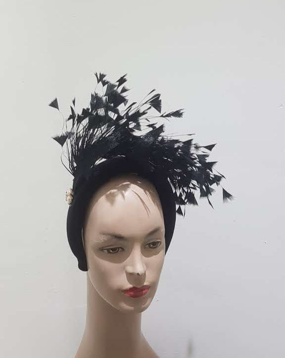 "Feather cluster on a padded headband with sinamay loops around the feathers"