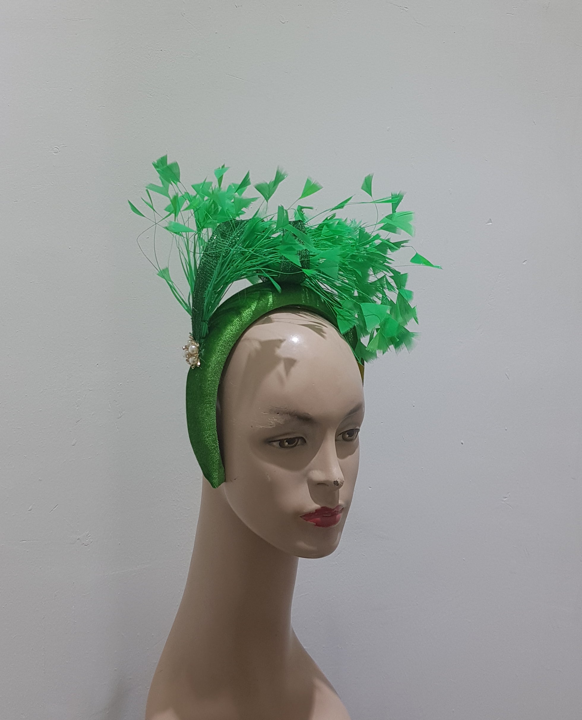 "Feather cluster on a padded headband with sinamay loops around the feathers"