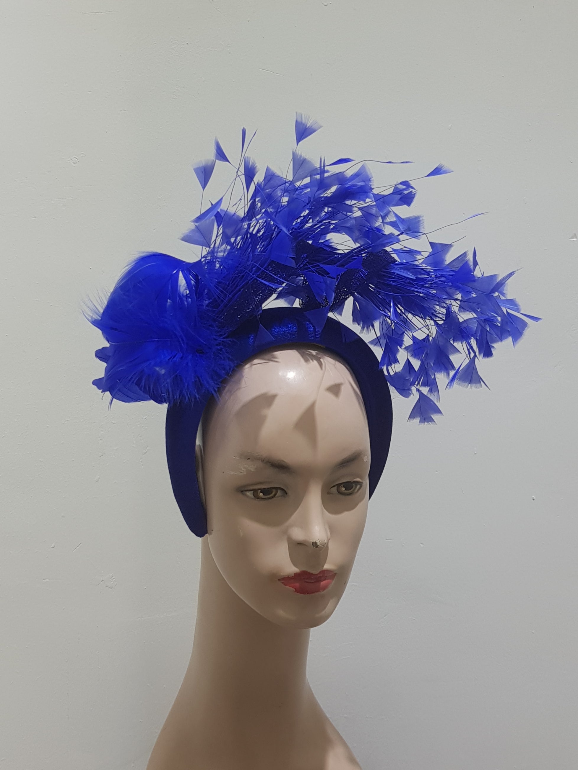 "Feather cluster on a padded headband with sinamay loops around the feathers"