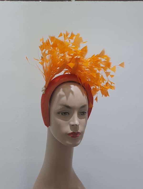 "Feather cluster on a padded headband with sinamay loops around the feathers"