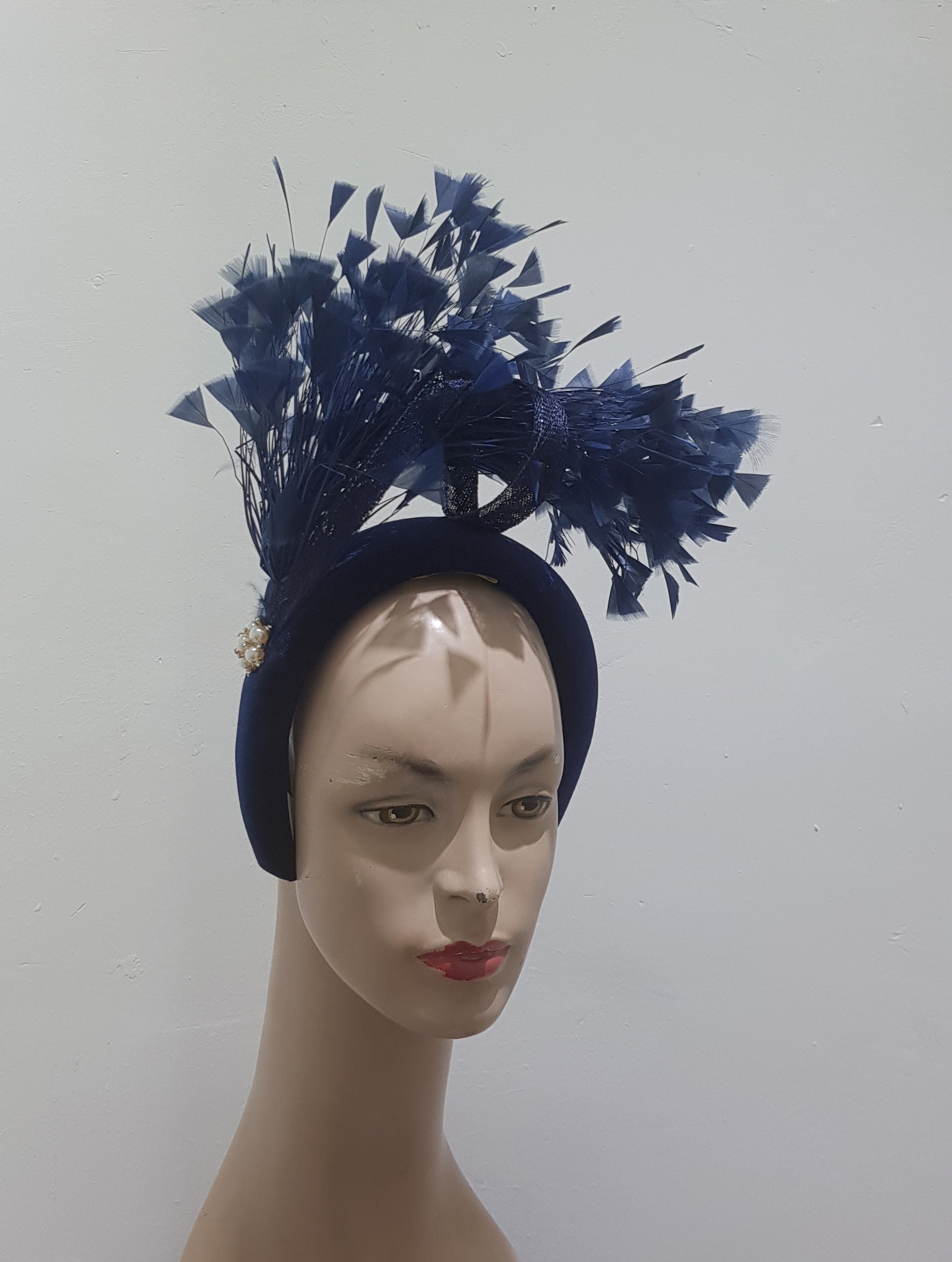 "Feather cluster on a padded headband with sinamay loops around the feathers"