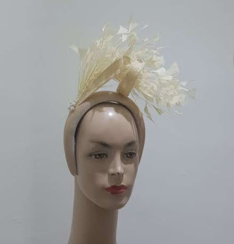 "Feather cluster on a padded headband with sinamay loops around the feathers"