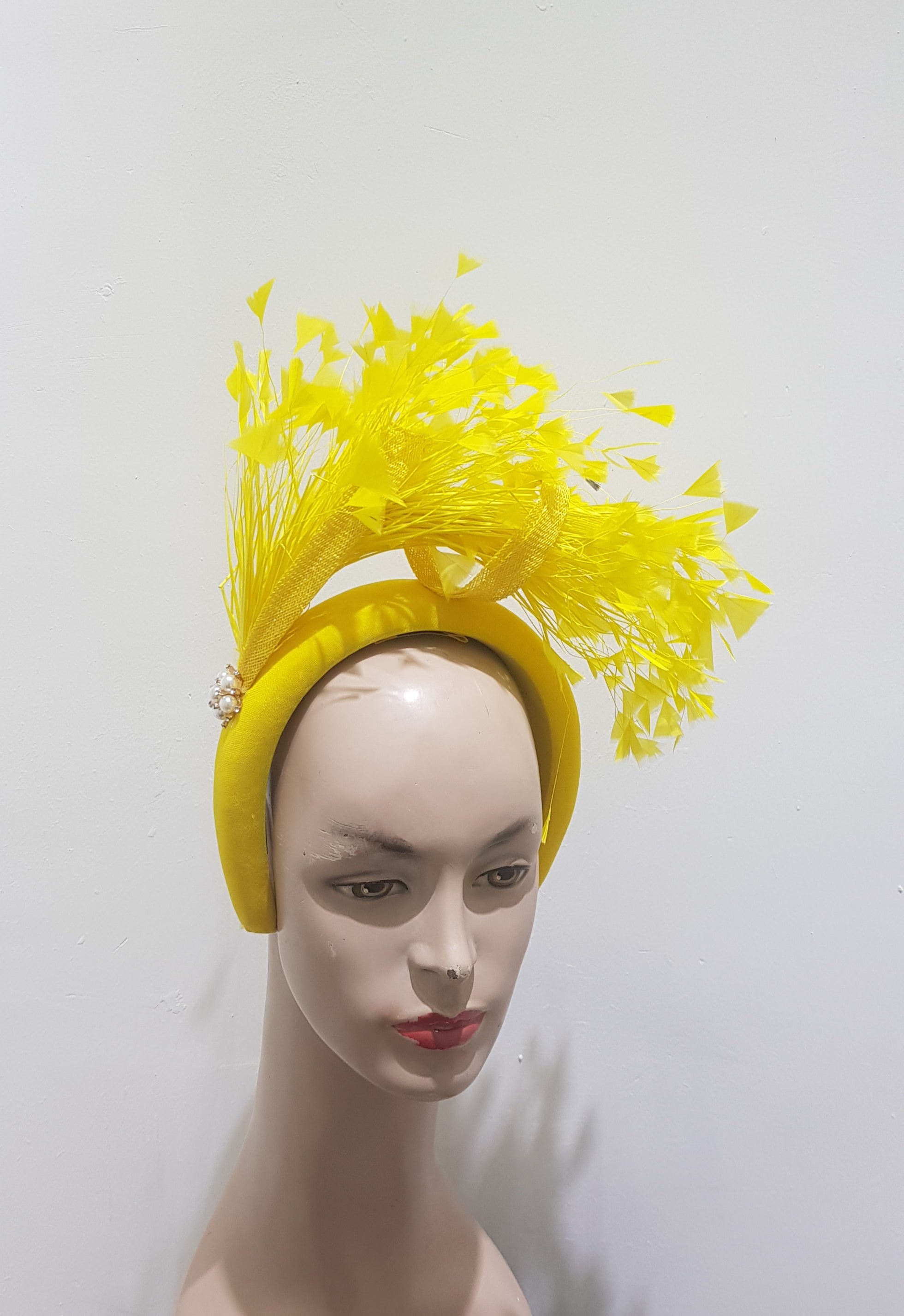 "Feather cluster on a padded headband with sinamay loops around the feathers"