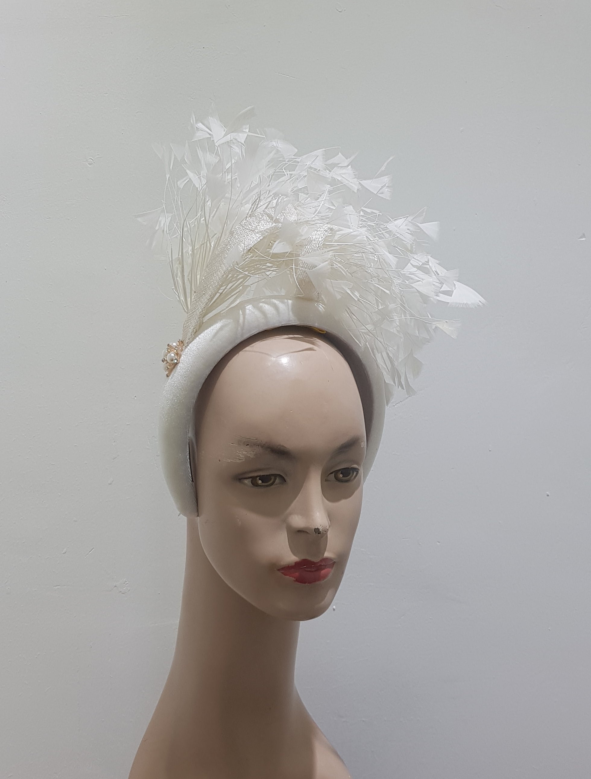 Feather cluster on a padded headband with sinamay loops around the feathers