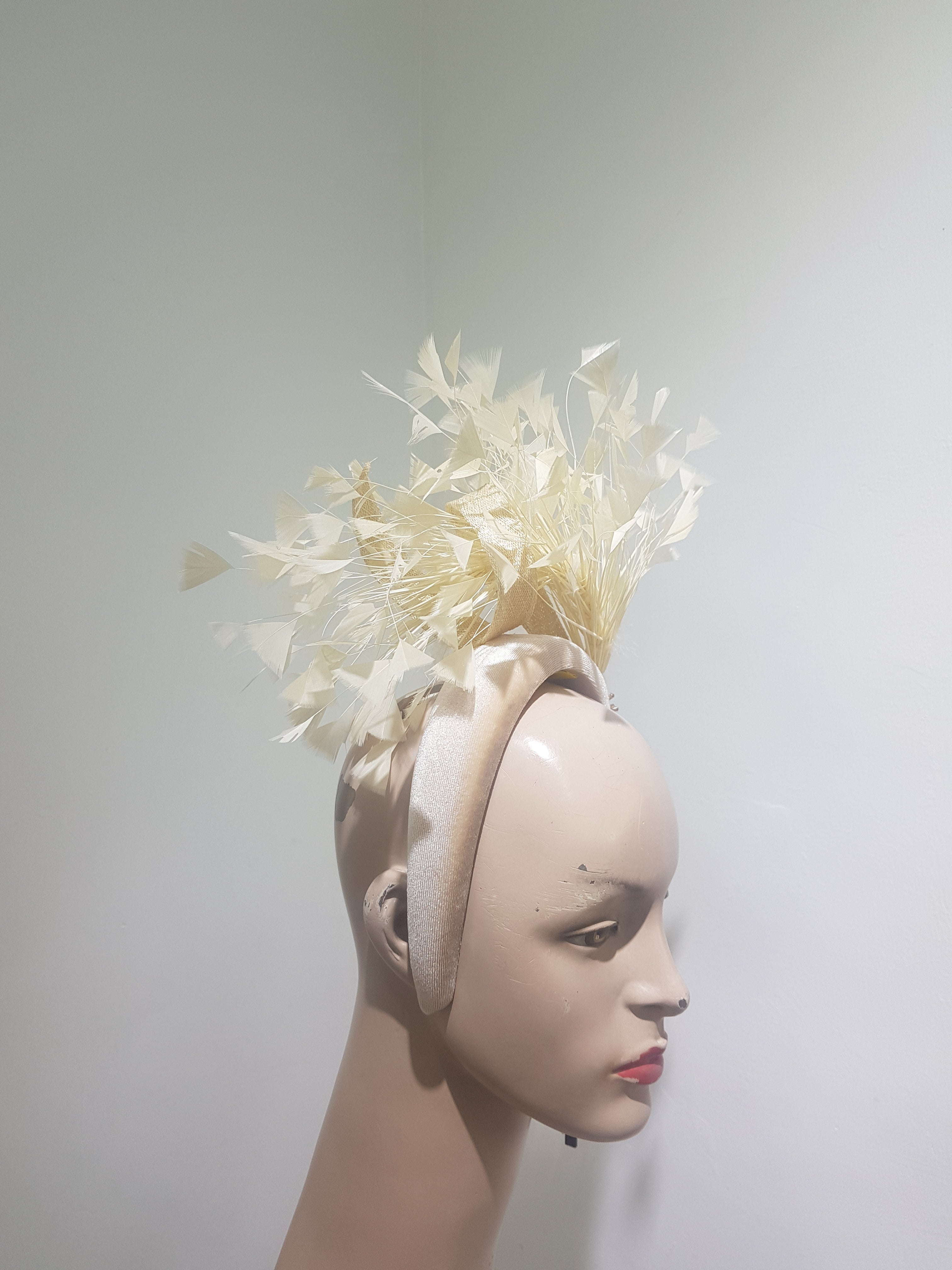 Feather cluster on a padded headband with sinamay loops around the feathers