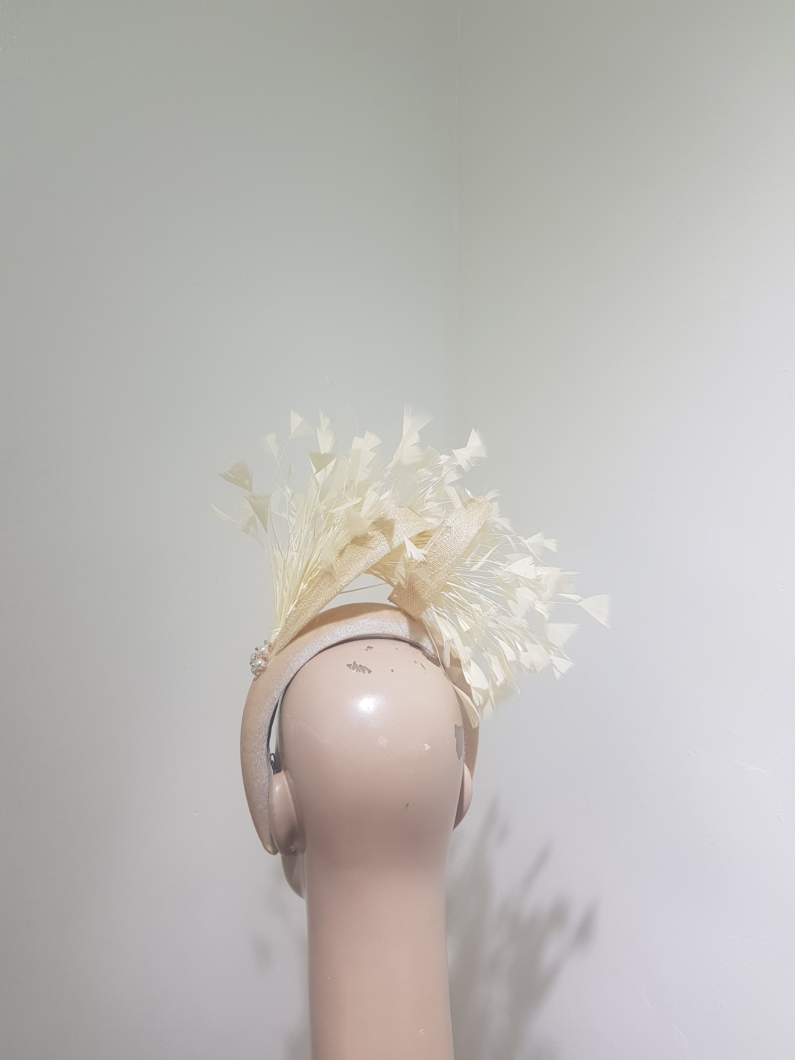 Feather cluster on a padded headband with sinamay loops around the feathers