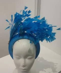 "Feather cluster on a padded headband with sinamay loops around the feathers"