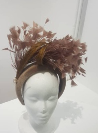 "Feather cluster on a padded headband with sinamay loops around the feathers"